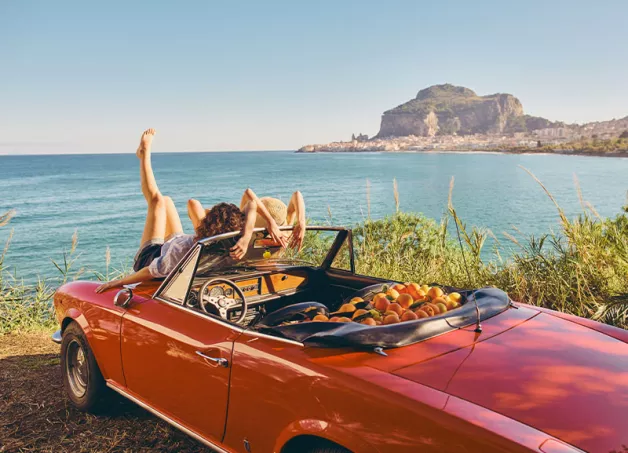 two girls relaxing on a convertible car